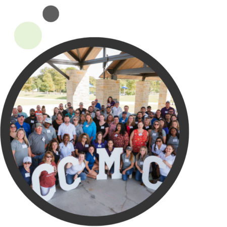 Large group photo of the CCMC team holding up giant CCMC letters
